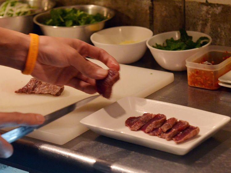 Cette photo prise le 1er octobre 2015 montre le chef Eiichi Tsuchiya préparant un carpaccio de viande de baleine dans son restaurant à Tokyo pour le festival de viande de baleine d'Ebisu.