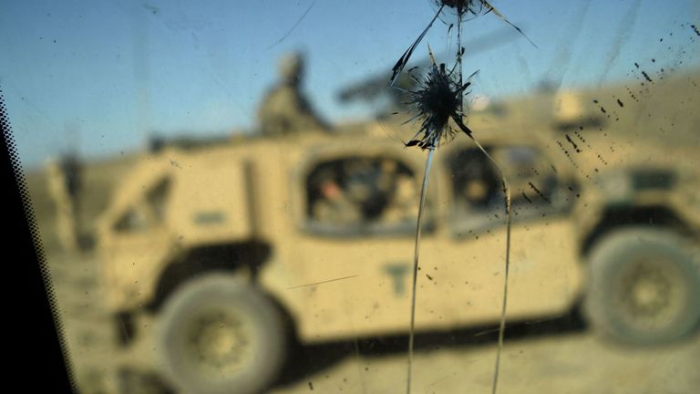 Soldats de l'armée américaine vus à travers une vitre fissurée d'un véhicule armé à un poste de contrôle 