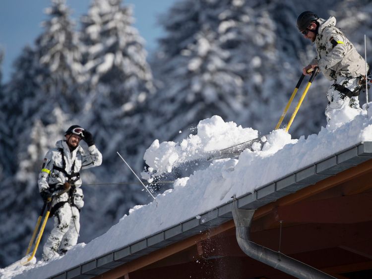 Des soldats de la Bundeswehr allemande enlèvent la neige du toit du Watzmann Therme le 11 janvier 2019 à Berchtesgaden, en Allemagne