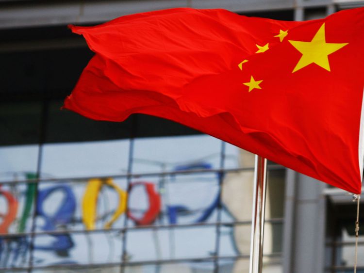 Le logo de Google apparaît dans les fenêtres du siège social de la société en Chine alors que le drapeau national chinois flotte dans le vent à Beijing le 23 mars 2010 après que le géant américain du Web ait annoncé qu'il ne filtrerait plus les résultats et redirigeait les Chinois du continent. les utilisateurs vers un site non censuré à Hong Kong - ce qui ferme effectivement le site continental. La décision de Google de fermer efficacement son moteur de recherche en chinois risque de freiner le développement d'Internet en Chine et d'isoler le Web local