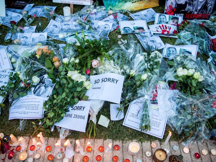 Cette photo montre des textes, des images et des bougies posées pendant que les Marocains rendent hommage à la Danoise Louisa Vesterager Jespersen et à la Norvégienne Maren Ueland, assassinées, à Rabat, devant l'ambassade de Norvège le 22 décembre 2018.