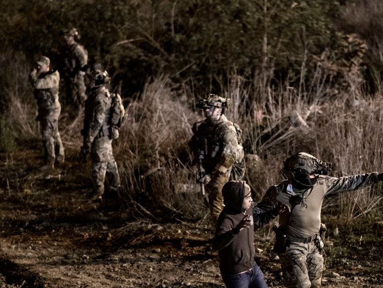 Un officier de la US Border Protection arrête un migrant qui a franchi la barrière de la frontière pour se rendre du côté américain à San Diego, en Californie, depuis Tijuana