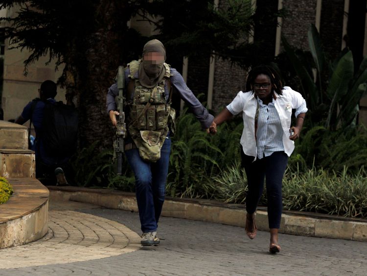 Un agent de sécurité évacue une femme blessée 