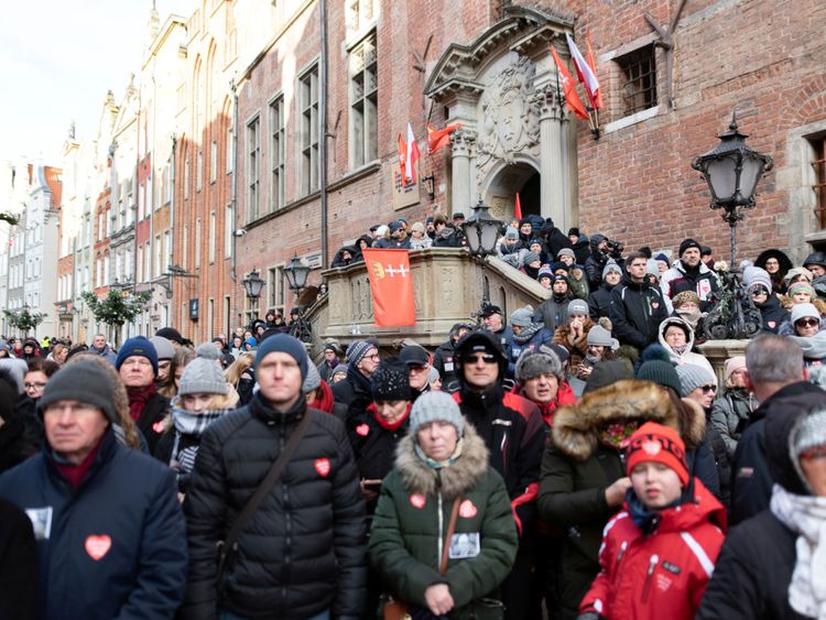 Personnes rassemblées à l'extérieur pour assister au service funèbre
