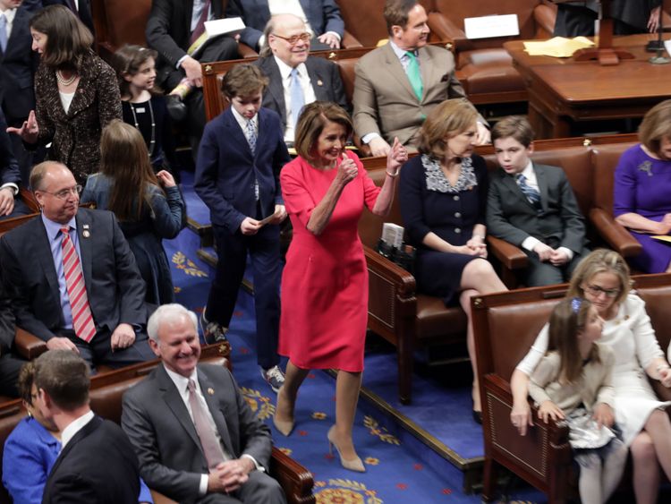 La représentante du Président désignée, Nancy Pelosi (D-CA) donne un double coup de pouce pour entrer dans la salle des séances.