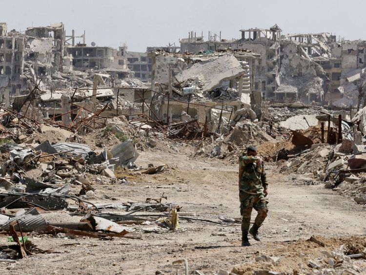 Un membre du régime syrien marche dans la destruction de la Ghouta orientale en avril 2018