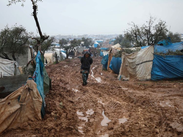 Des Syriens déplacés marchent dans un camp inondé près de Kah, dans la province d'Idlib, au nord-est de la Syrie.