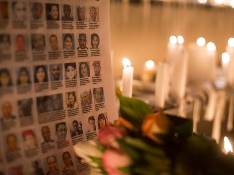   Les photographies des victimes du centre commercial Westgate sont placées à côté de bougies allumées à l'extérieur du centre commercial Westgate le 28 septembre 2013 à Nairobi, au Kenya.