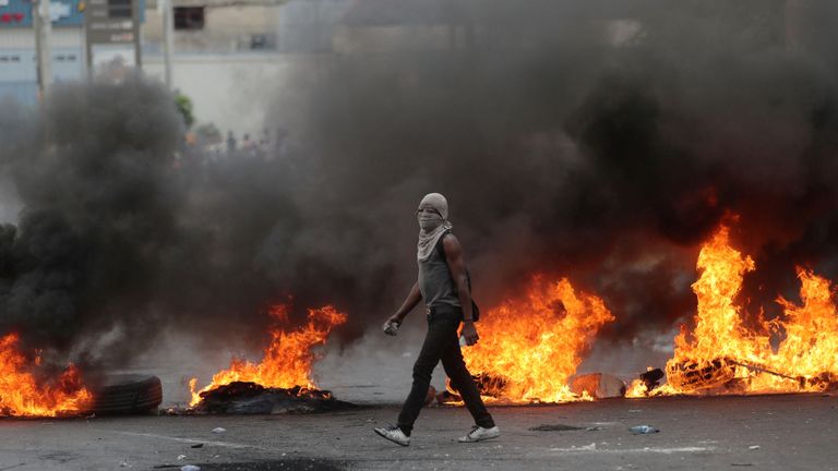 Un manifestant passe devant une barricade en flammes lors des manifestations du 15 février
