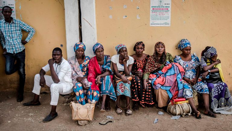 Un groupe de femmes assises à l'entrée d'un bureau de vote à Gombi