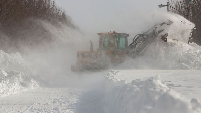 La neige profonde est enlevée d'une route à Buffalo, dans l'état de New York