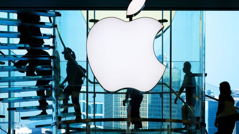 Les employés passent devant le grand panneau Apple devant un magasin