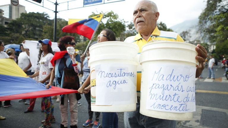 Les signes de cet homme indiquent: "Nous avons besoin d'eau". et à droite, Maduro, tu paieras pour la mort des innocents.