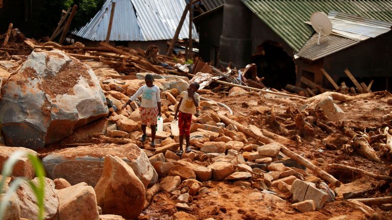 Des enfants transportent de l'eau potable sur les débris créés par le cyclone Idai au Peacock Growth Point à Chimanimani, à la frontière avec le Mozambique, au Zimbabwe. 22 mars 2019