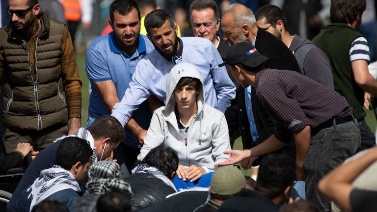 Zaid Mustafa (C, en fauteuil roulant), qui a été blessé dans les attaques arrive pour prier