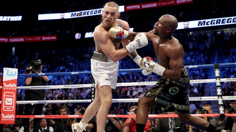   Floyd Mayweather Jr donne un coup de poing à Conor McGregor lors de leur match de boxe super-poids welter