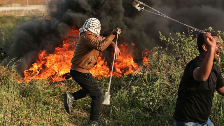 Des manifestants palestiniens utilisent des lance-pierres pour lancer des pierres lors d'affrontements avec les forces israéliennes