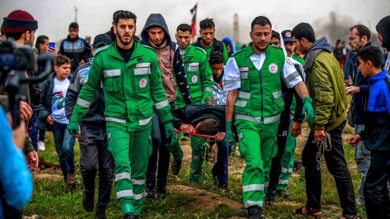 Des ambulanciers emmènent un homme sur une civière lors des manifestations à la frontière avec Gaza