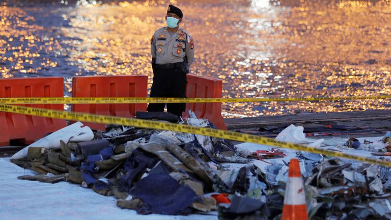 Un policier monte la garde près de l'épave du vol JT610 de Lion Air au port de Tanjung Priok à Jakarta