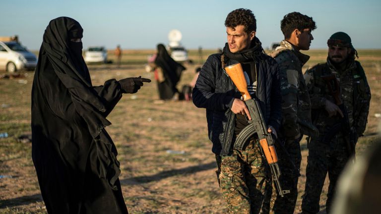 Un membre du SDF parle avec une femme qui quitte l'Etat islamique