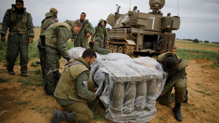 Des soldats israéliens couvrent des obus près de la frontière de Gaza