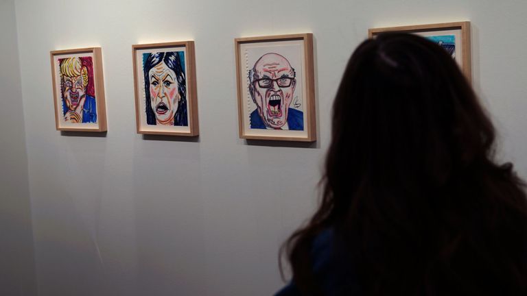 Les gens regardent les oeuvres de Jim Carrey lors de la foire Outsider Art Fair à New York