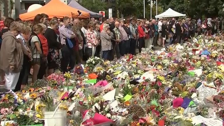 Les personnes en deuil se rassemblent et laissent des fleurs comme un pays se souvient des victimes