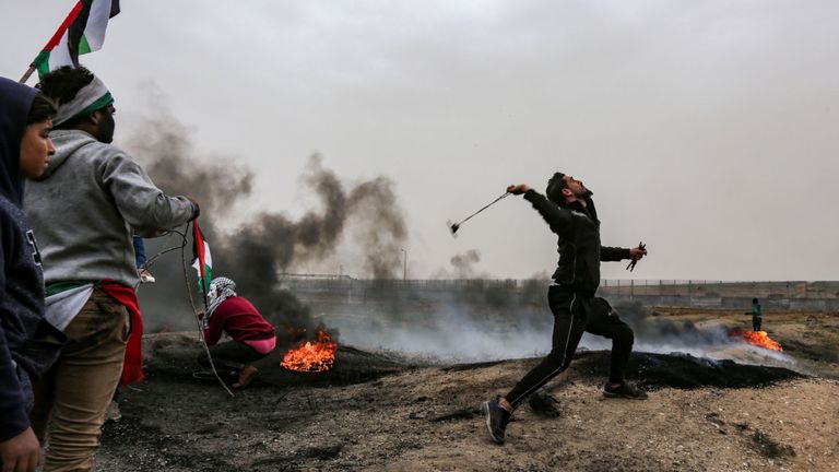 Un manifestant palestinien utilisant une fronde pour cibler les forces israéliennes