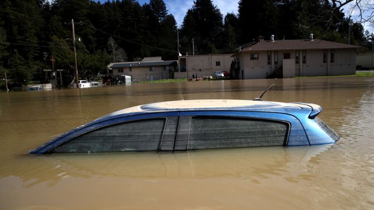 Les voitures étaient presque complètement submergées dans les eaux brunes boueuses d’une rivière débordée