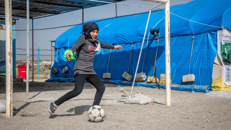 Sara, 14 ans, joue dans les buts lors d'un match de football sur l'espace adapté aux enfants de Save the Children dans le camp d'Ein Issa, en Syrie.