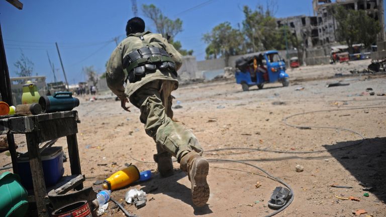Un soldat somalien se met à l'abri sur les lieux de deux explosions déclenchées près des ministères des Travaux publics et du Travail