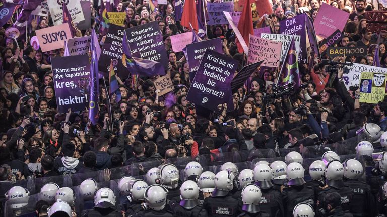 Une pancarte indique: "Nous sommes en rébellion pour la liberté". Alors que les femmes crient des slogans alors que des policiers turcs anti-émeute tentent de les repousser lors d'un rassemblement marquant la Journée internationale de la femme sur l'avenue Istiklal à Istanbul le 8 mars 2019
