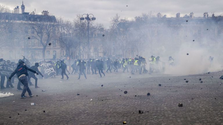 Des manifestants gilets jaunes jettent des pavés dans les rues de Paris