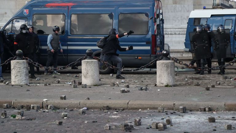 Des pierres pavées jonchent le sol alors que la police tente de maintenir l'ordre