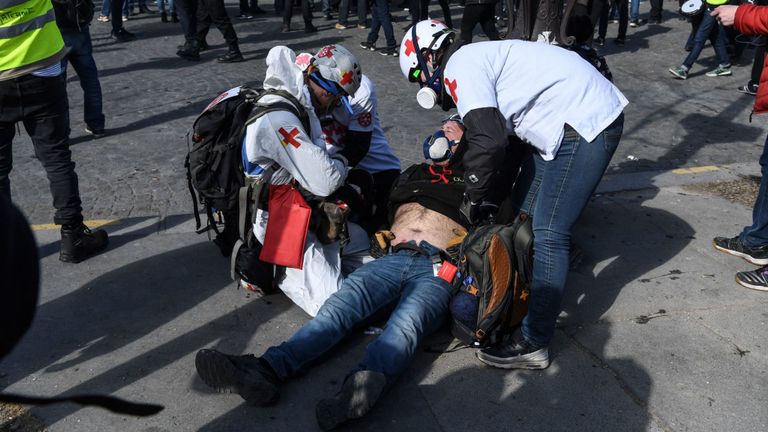 Un manifestant blessé reçoit des soins alors qu'il repose sur le sol blessé