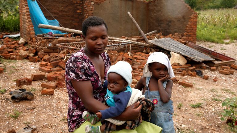 Nomatter Ncube et ses enfants sont assis à côté de leur maison de famille emportée par le cyclone Idai dans le district de Chimanimani, au Zimbabwe, le 18 mars 2019. REUTERS / Philimon Bulawayo
