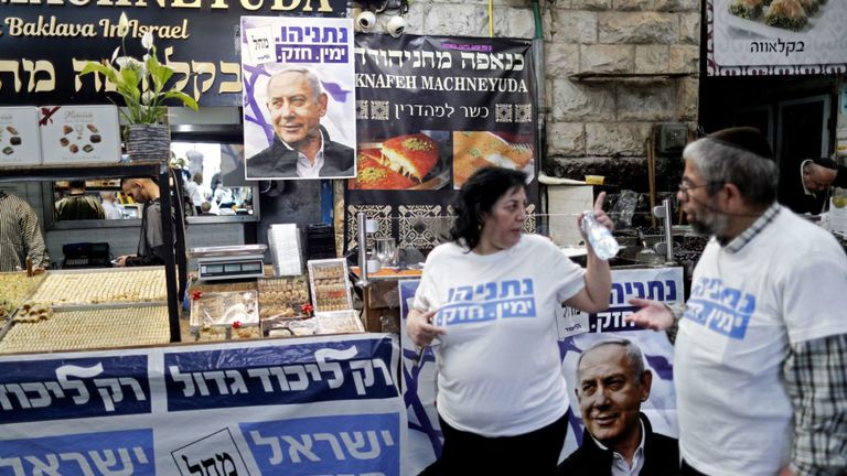 Des partisans du Premier ministre israélien, Benjamin Netanyahu, se tiennent à côté d'affiches portant son portrait au marché Machane Yehuda à Jérusalem le 8 avril 2019, un jour avant les élections. - Les Israéliens votent le 9 avril lors d’une élection décisive sur la prolongation du mandat du Premier ministre Benjamin Netanyahu au pouvoir, malgré des accusations de corruption à son encontre et un défi de taille lancé par un ancien chef militaire. (Photo de THOMAS COEX / AFP) (Le crédit photo doit se lire comme suit: THOMAS COEX / AFP / Getty Images
