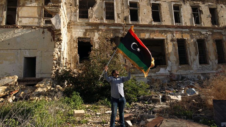 Un homme libyen brandit le drapeau national lors d'un rassemblement pour marquer le huitième anniversaire du soulèvement dans la deuxième ville de Benghazi, en Libye, le 17 février 2019. - Huit ans après la révolte en Libye contre Moammar Kadhafi régime autoritaire, un État moderne et démocratique reste un rêve lointain dans un pays qui glissait de crise en crise