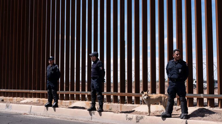 La police des frontières mexicaine se tient devant la clôture en acier et ardoise qui sépare les deux pays