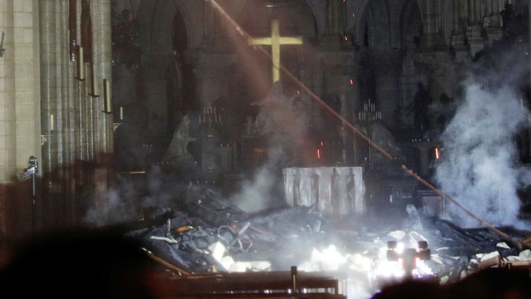 La fumée monte autour de l'autel devant la croix à l'intérieur de Notre Dame