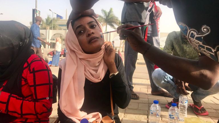Une femme a le drapeau soudanais peint sur son visage