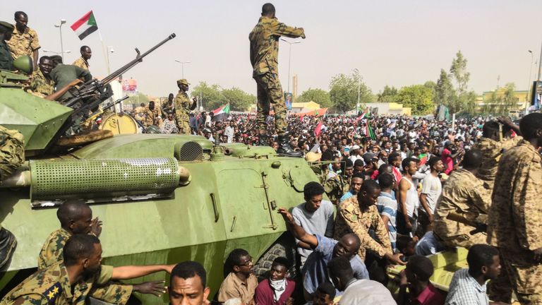 Des soldats soudanais montent la garde sur des véhicules militaires blindés dans la capitale, Khartoum