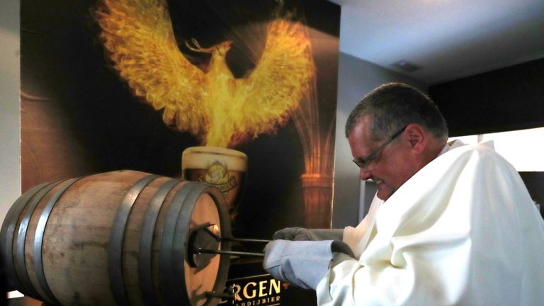 Le père Karel de Norbertine marque un tonneau de bière Grimbergen, symbolisé par un phénix, à l'abbaye belge de Grimbergen après avoir annoncé que les moines retourneraient à la brasserie après une pause de deux siècles, à Grimbergen, Belgique, le 21 mai 2019. REUTERS / Yves Herman