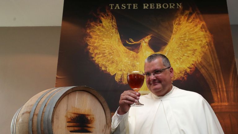 Le Père Karel Norbertine porte une bière Grimbergen symbolisée par un phénix à l'abbaye belge de Grimbergen après avoir annoncé que les moines retourneraient à la brasserie après une pause de deux siècles à Grimbergen, Belgique, le 21 mai 2019. REUTERS / Yves Herman