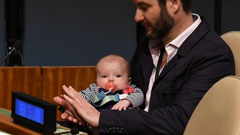 Clarke Gayford (C) applaudit en tenant sa fille Neve Te Aroha Ardern Gayford, sa partenaire, Jacinda Ardern, Premier ministre et ministre des Arts, de la Culture et du Patrimoine, et de la Sécurité nationale et des renseignements de la Nouvelle-Zélande, lors du Sommet sur la paix de Nelson Mandela, le 24 septembre 2018, un jour avant le début du débat général de la 73e session de l'Assemblée générale aux Nations Unies à New York