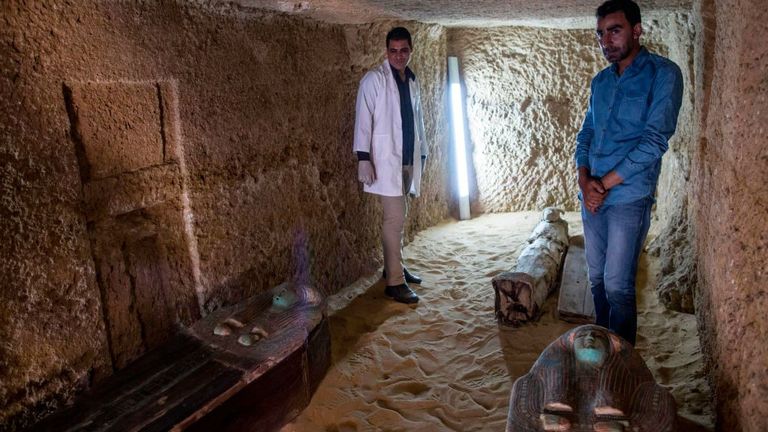 Les ouvriers de l'excavation se tiennent le 4 mai 2019 à côté de sarcophages dans un cimetière situé sur le plateau pyramidal de Gizeh, dans la banlieue sud-ouest de la capitale égyptienne, à la suite de la découverte de plusieurs tombeaux et de sépultures. (Photo de MAHMOUD KHALED / AFP) (Le crédit photo devrait correspondre à MAHMOUD KHALED / AFP / Getty Images)