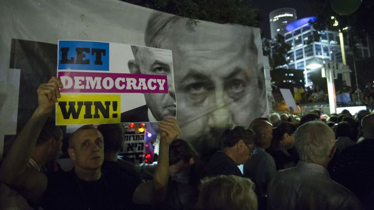 Un Israélien tient une pancarte lors d’une manifestation contre la loi sur l’immunité de Netanyahu. le 25 mai 2019 à Tel Aviv, Israël