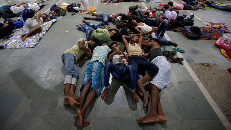 Des personnes bloquées se reposent à l'intérieur d'une gare après l'annulation des trains entre Kolkata et Odisha