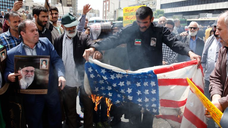 Des manifestants iraniens brûlent un drapeau américain improvisé lors d'un rassemblement dans la capitale, Téhéran