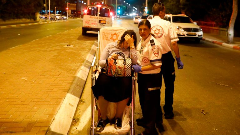 Une femme blessée est évacuée du site de l'attaque à la roquette en Israël